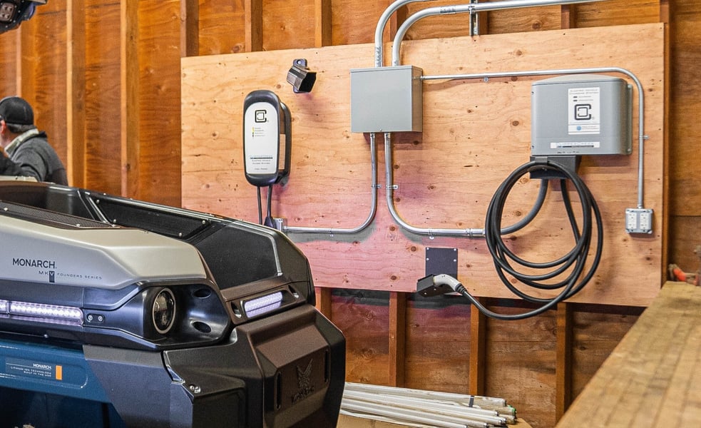 Electric tractor docked at a charging station.